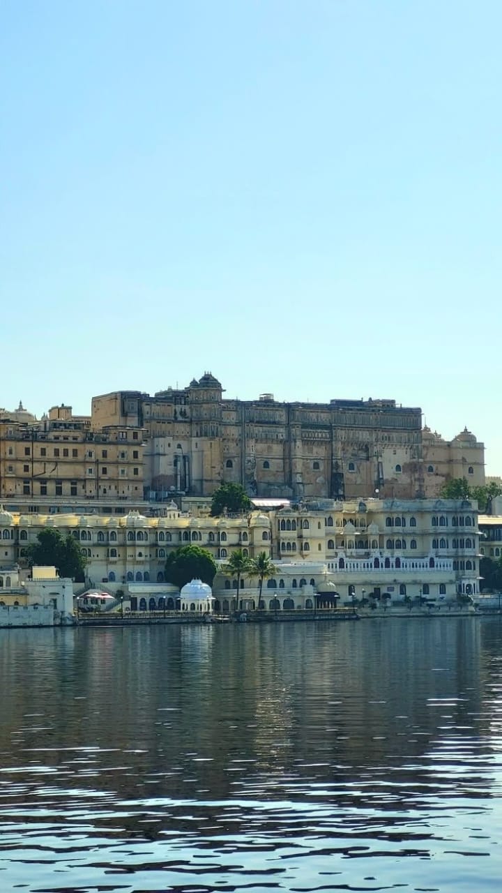 Historic building complex by a lake with clear blue sky